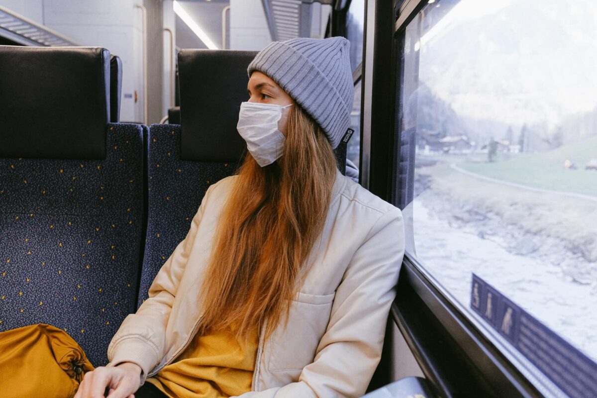 A woman on a train with a mask on