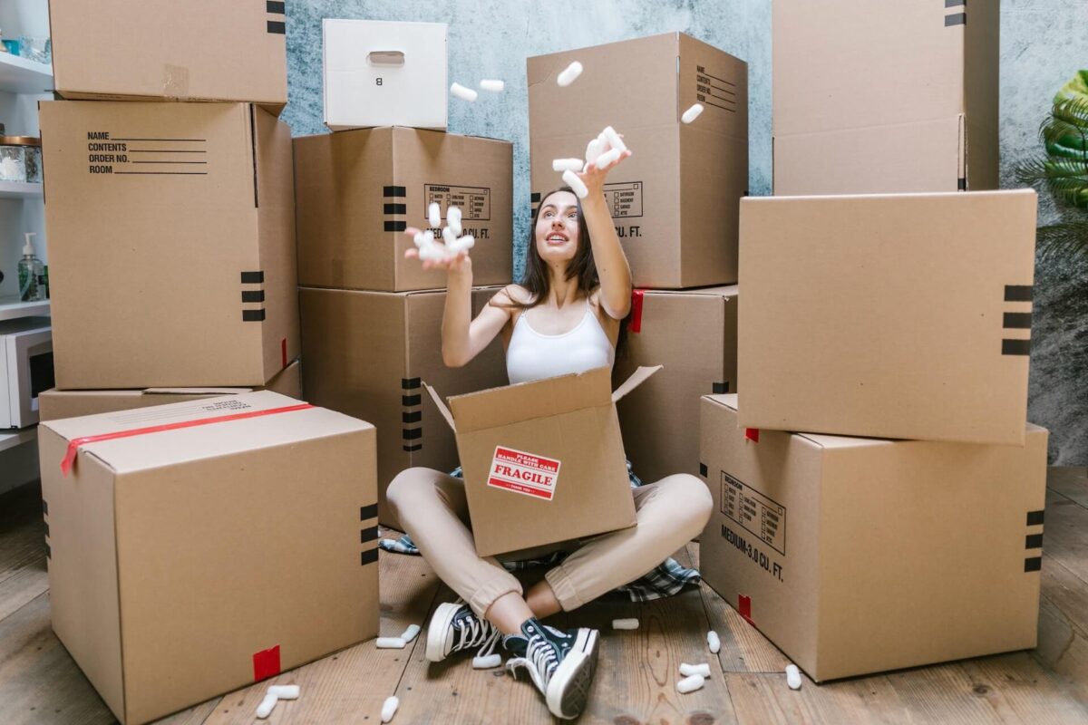 A woman sitting among many cardboard boxes