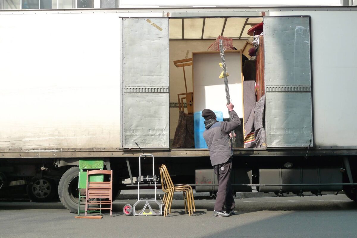 A person loading an item into a truck