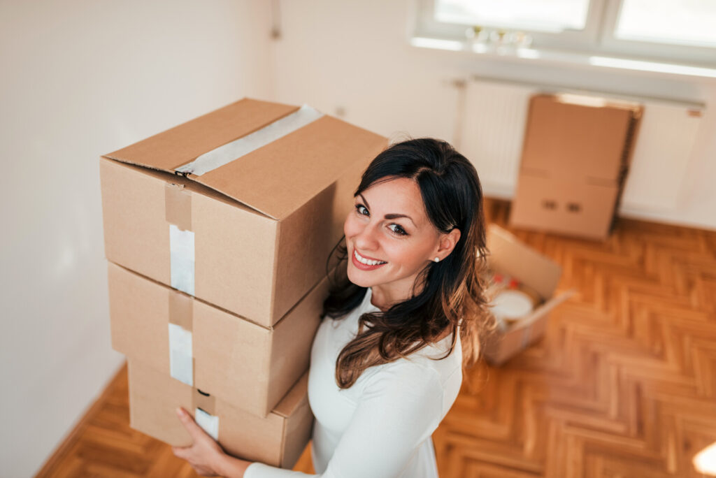 A woman holding boxes and smiling