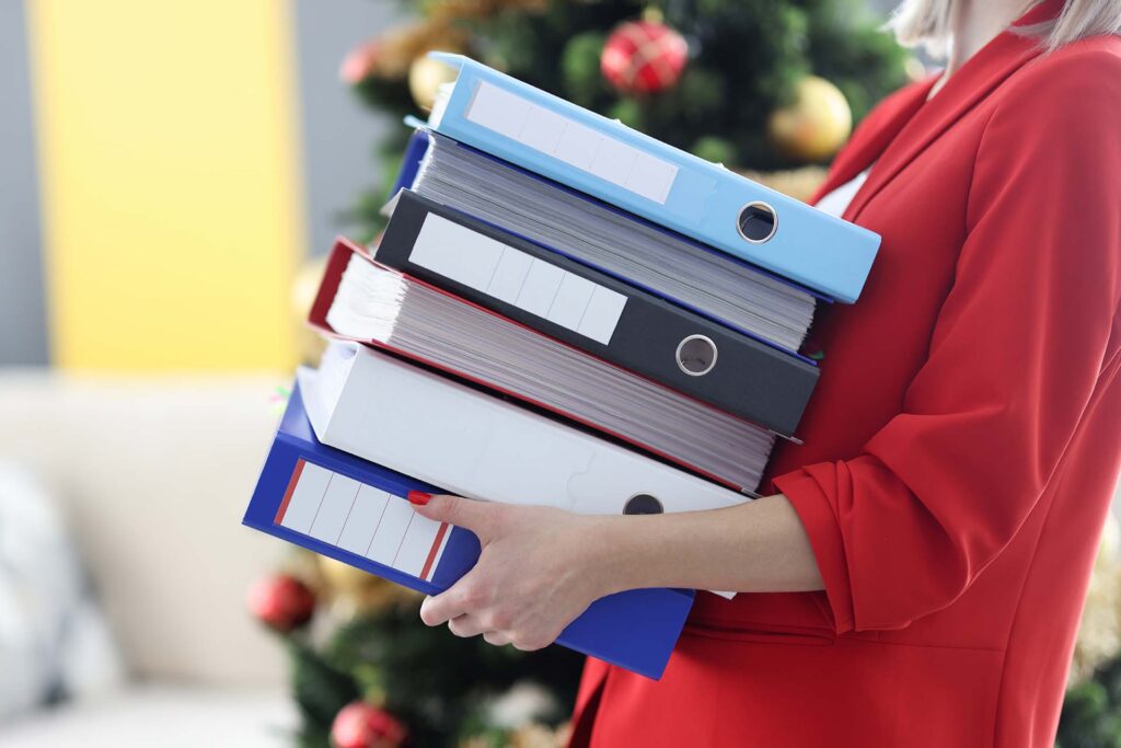 Woman is holding heavy stack of folders with documents. Women in business concept
