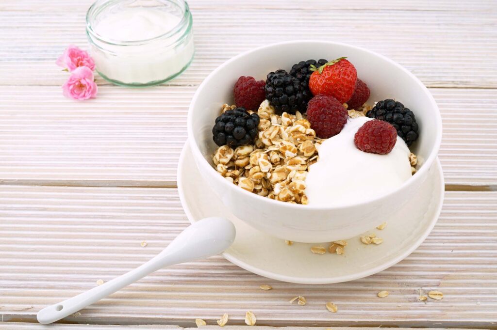 A white ceramic bowl filled with fruit and oatmeal
