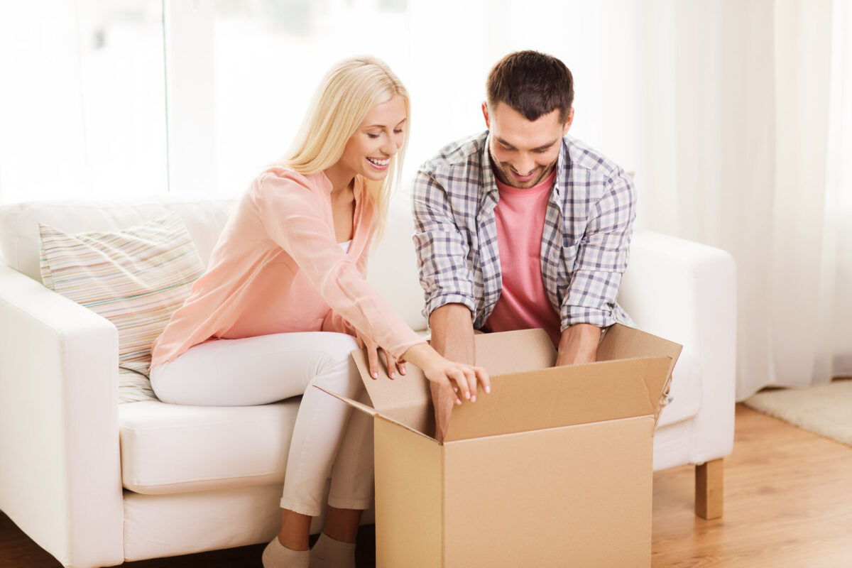 Woman and man smiling and packing a box